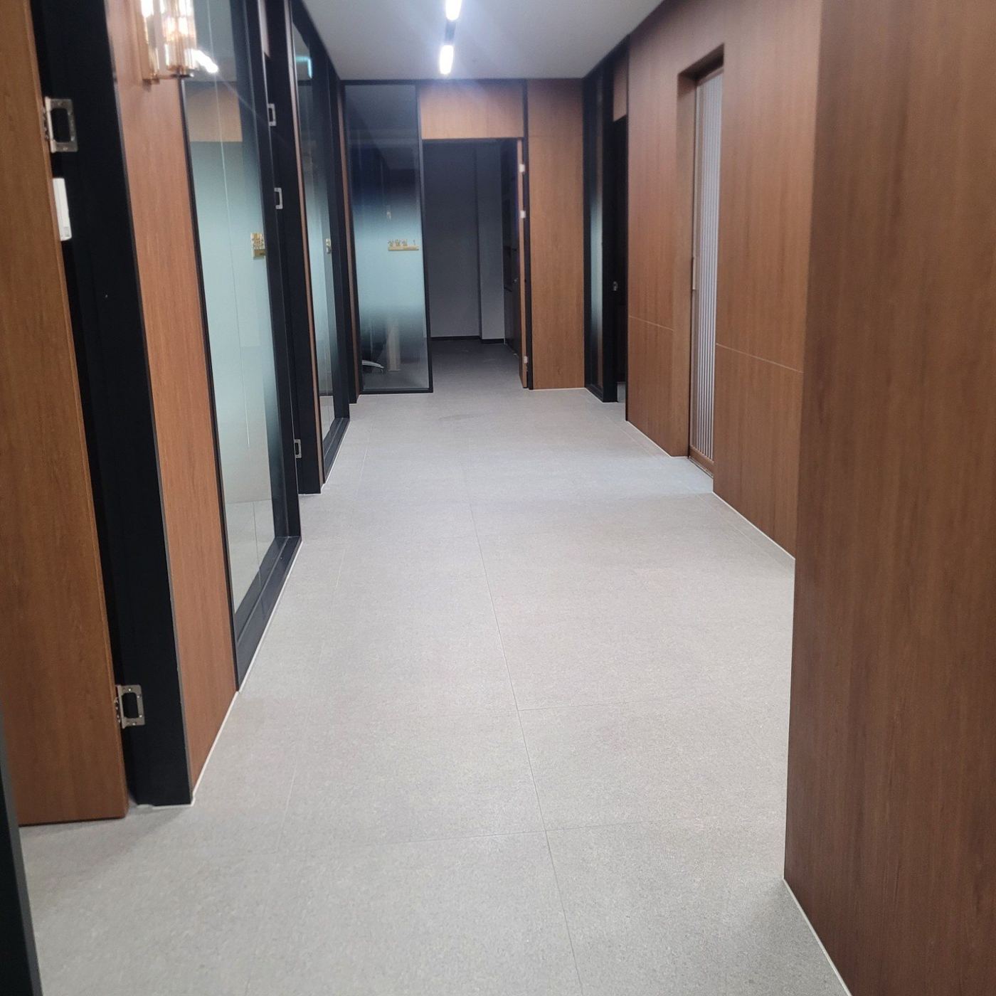 모던한 사무실에서 유리 벽면을 관리하는 작업자